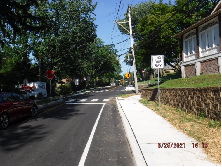 Final asphalt wearing course pavement  with line striping and signs on Edge Hill Road looking east towards Bradfield Road.